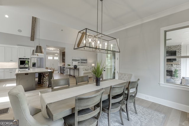 4781 Falling Brook Dr, Flowery Branch, GA 30542 - dining space with light wood-type flooring, plenty of natural light, baseboards, and a chandelier