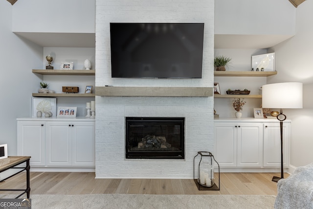 4781 Falling Brook Dr, Flowery Branch, GA 30542 - living area featuring light wood-style flooring and a brick fireplace