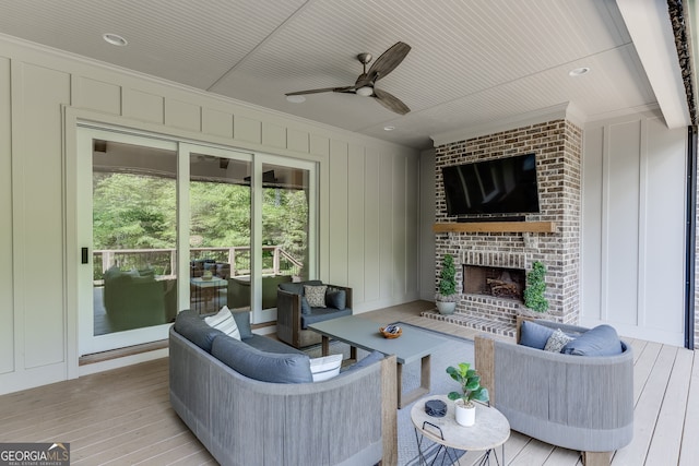 4781 Falling Brook Dr, Flowery Branch, GA 30542 - living room featuring crown molding, ceiling fan, a decorative wall, light wood finished floors, and a brick fireplace