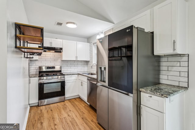 232 Apple Branch Dr, Woodstock, GA 30188 - kitchen featuring appliances with stainless steel finishes, under cabinet range hood, a sink, tasteful backsplash, and vaulted ceiling