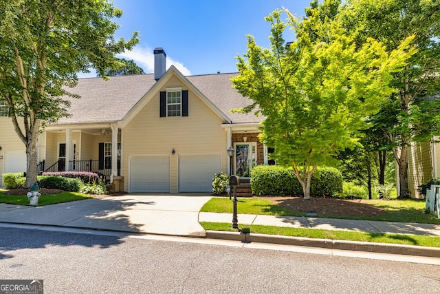 111 Portico Pl, Newnan, GA 30265 - traditional home featuring driveway, a shingled roof, a chimney, and covered porch