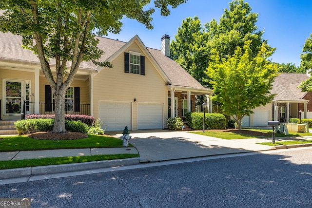111 Portico Pl, Newnan, GA 30265 - view of front of home with driveway, a chimney, covered porch, and roof with shingles