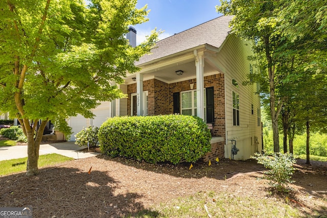111 Portico Pl, Newnan, GA 30265 - view of property exterior featuring a garage, brick siding, a chimney, and a shingled roof