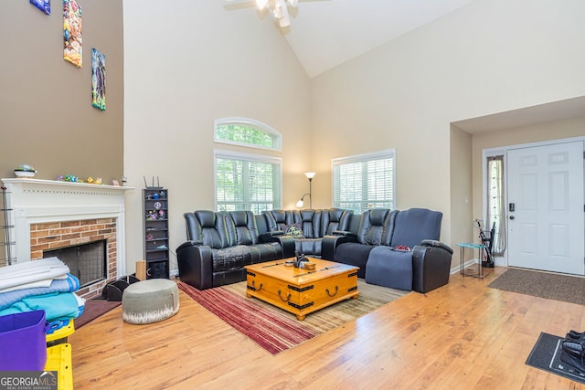 111 Portico Pl, Newnan, GA 30265 - living area with high vaulted ceiling, wood-type flooring, a ceiling fan, and a brick fireplace