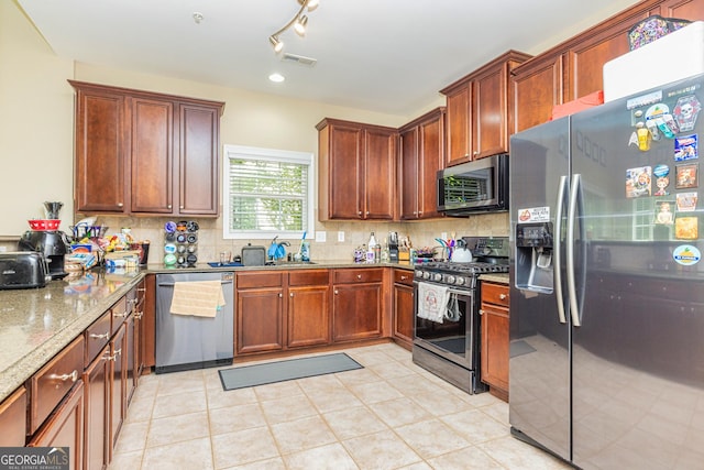 111 Portico Pl, Newnan, GA 30265 - kitchen featuring stainless steel appliances, light stone counters, tasteful backsplash, and a sink