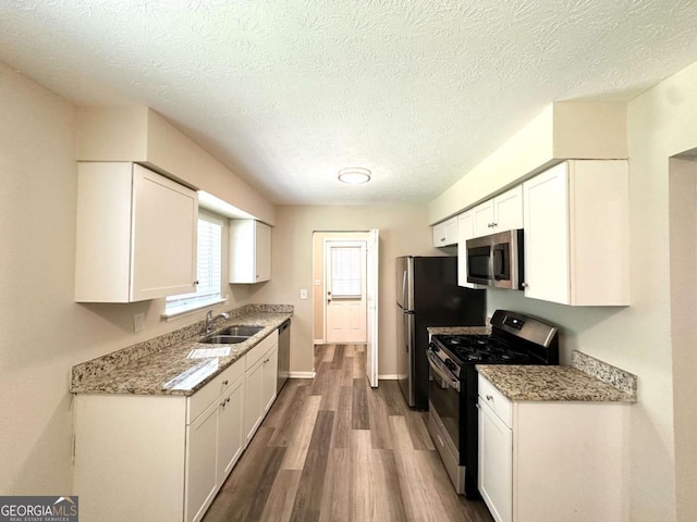 3730 Stephanie Dr SW, Atlanta, GA 30331 - kitchen with stainless steel appliances, a sink, dark wood finished floors, white cabinetry, and a textured ceiling