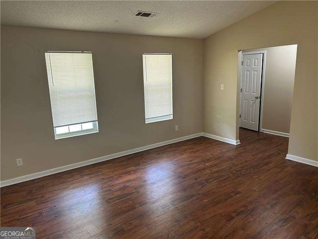 6536 Rebecca Lou Ln, Lithonia, GA 30058 - spare room with dark wood-type flooring, vaulted ceiling, and a textured ceiling