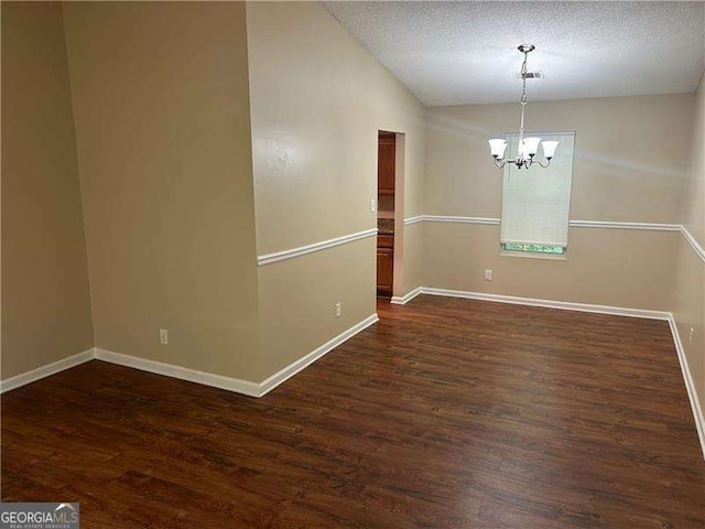 6536 Rebecca Lou Ln, Lithonia, GA 30058 - unfurnished room with a chandelier, dark wood-style flooring, vaulted ceiling, and a textured ceiling