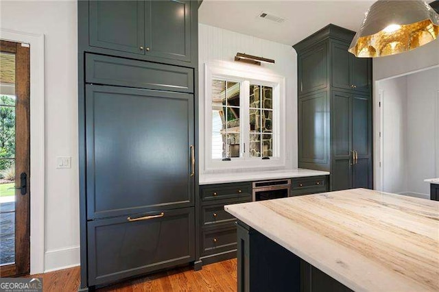 1830 Maple St, Carrollton, GA 30117 - kitchen featuring wood finished floors, oven, and light stone counters