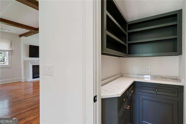 1830 Maple St, Carrollton, GA 30117 - kitchen with open shelves, wood finished floors, baseboards, light stone countertops, and beamed ceiling