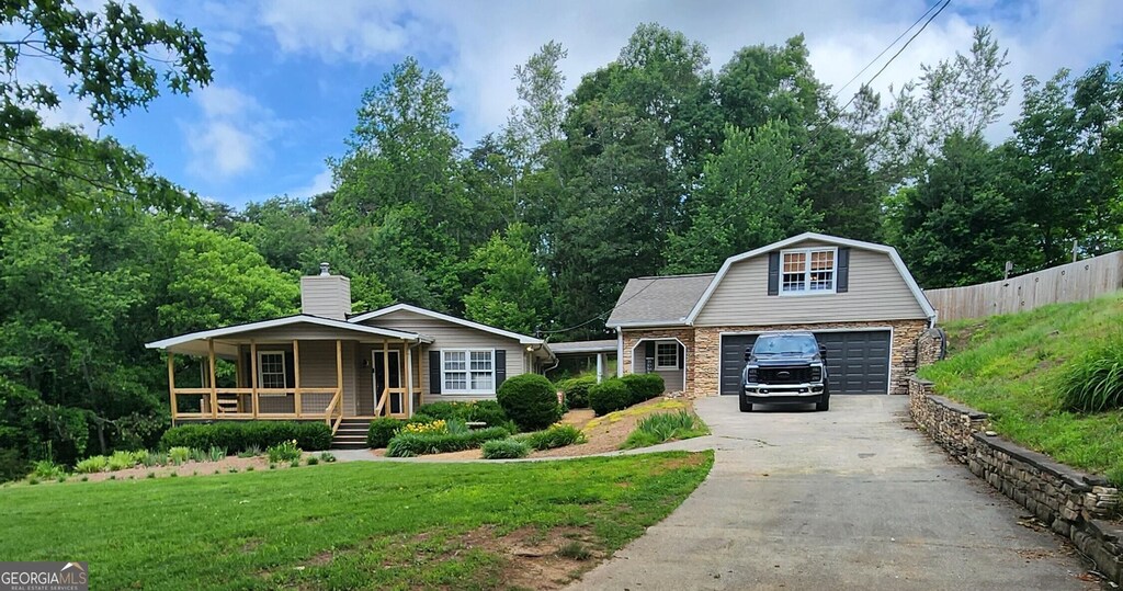 345 Davis Rd W, Fairmount, GA 30139 - view of front of property with covered porch, an outdoor structure, driveway, stone siding, and a gambrel roof