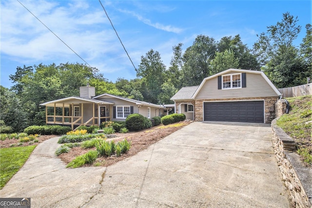 345 Davis Rd W, Fairmount, GA 30139 - view of front of home featuring concrete driveway, a gambrel roof, a garage, covered porch, and stone siding