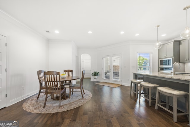 4044 Andover Cir, Mcdonough, GA 30252 - dining area with arched walkways, dark wood-style flooring, baseboards, recessed lighting, and crown molding