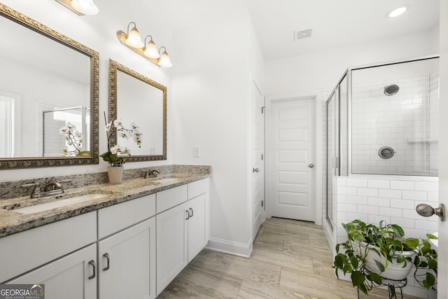 4044 Andover Cir, Mcdonough, GA 30252 - bathroom with a stall shower, double vanity, baseboards, and wood finished floors
