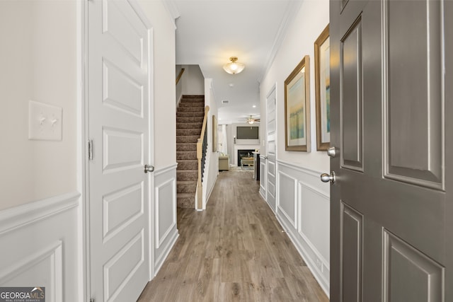 237 Orion Dr, Dalton, GA 30720 - hallway featuring wainscoting, light wood-style floors, stairway, a decorative wall, and crown molding