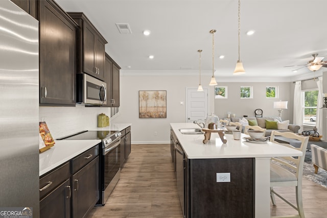 237 Orion Dr, Dalton, GA 30720 - kitchen with appliances with stainless steel finishes, open floor plan, ornamental molding, wood finished floors, and an island with sink