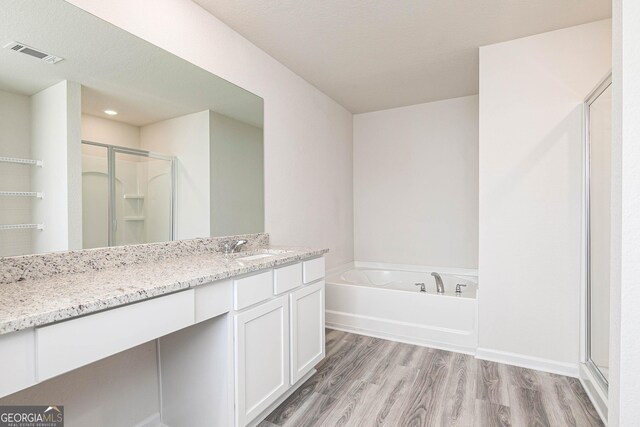 303 Limestone Cir, Conyers, GA 30013 - bathroom with wood finished floors, a stall shower, vanity, a bath, and baseboards