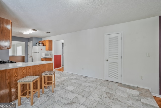 3524 Forest Downs Cv, Decatur, GA 30034 - kitchen with white appliances, light countertops, baseboards, light marble finish floors, and a textured ceiling