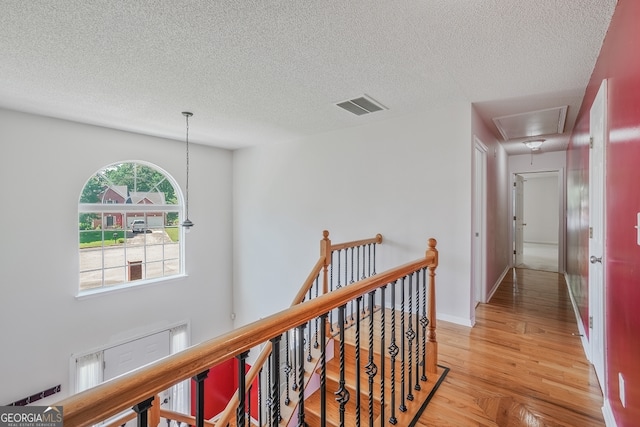 3524 Forest Downs Cv, Decatur, GA 30034 - hallway with attic access, a textured ceiling, light wood-style flooring, and an upstairs landing