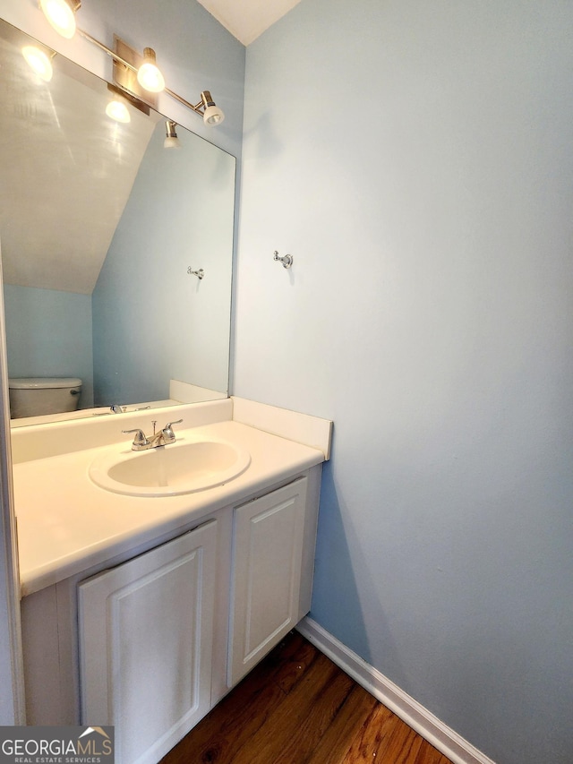 10900 Wittenridge Dr Unit H8, Alpharetta, GA 30022 - half bath featuring wood finished floors, vanity, vaulted ceiling, toilet, and baseboards