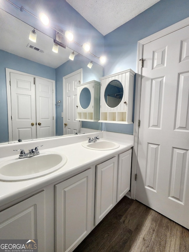 10900 Wittenridge Dr Unit H8, Alpharetta, GA 30022 - bathroom featuring double vanity, wood finished floors, and a textured ceiling