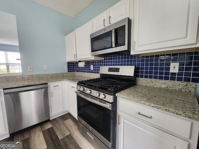 10900 Wittenridge Dr Unit H8, Alpharetta, GA 30022 - kitchen with appliances with stainless steel finishes, white cabinets, dark wood-style flooring, and backsplash