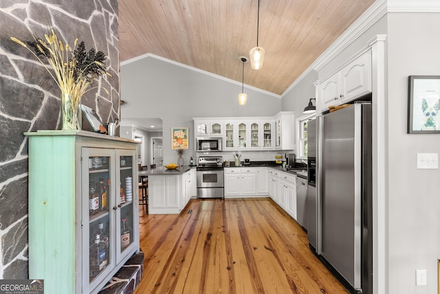 1431 Tame Turkey Rd, Lakemont, GA 30552 - kitchen with appliances with stainless steel finishes, dark countertops, crown molding, white cabinetry, and pendant lighting