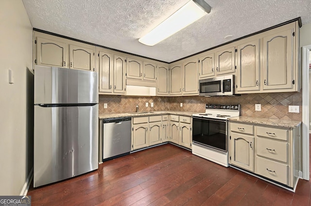 299 Fieldview Dr, Auburn, GA 30011 - kitchen with appliances with stainless steel finishes, a textured ceiling, cream cabinetry, dark wood finished floors, and backsplash