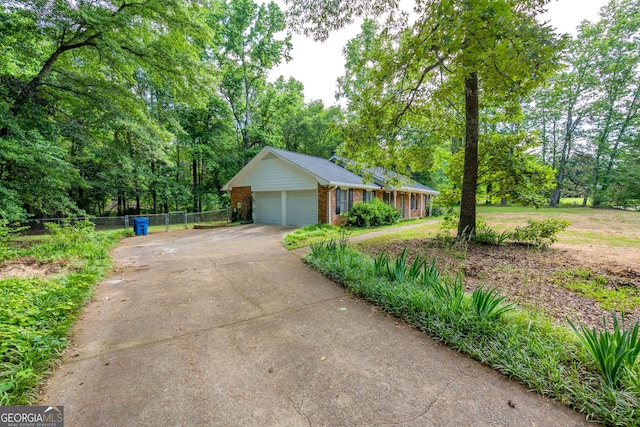 299 Fieldview Dr, Auburn, GA 30011 - view of front of home with brick siding, driveway, an attached garage, and view of scattered trees