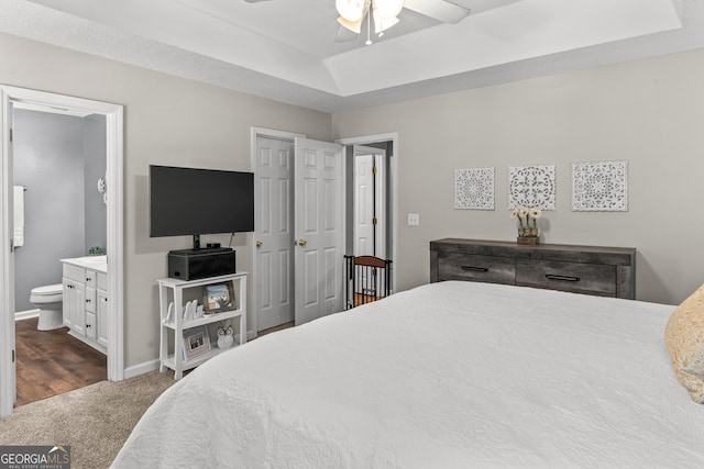 230 Hannah Dr, Colbert, GA 30628 - bedroom featuring dark colored carpet, a tray ceiling, ensuite bathroom, baseboards, and a ceiling fan