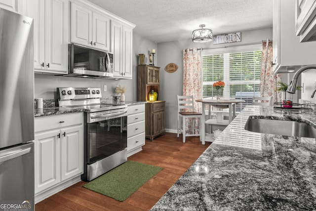 230 Hannah Dr, Colbert, GA 30628 - kitchen featuring appliances with stainless steel finishes, a sink, white cabinetry, dark wood finished floors, and a textured ceiling
