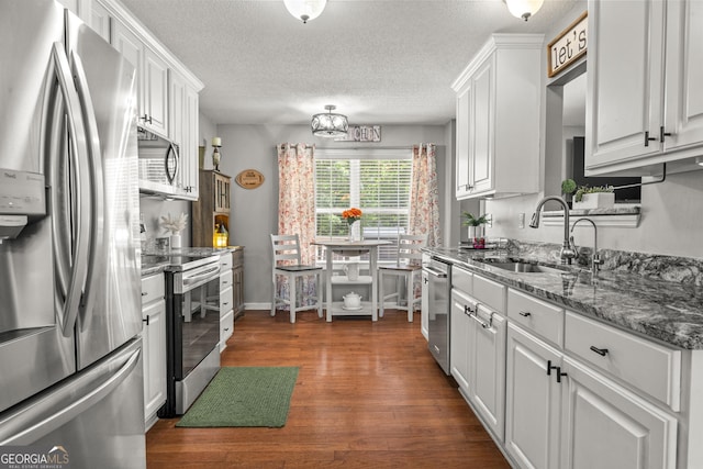 230 Hannah Dr, Colbert, GA 30628 - kitchen featuring appliances with stainless steel finishes, a sink, white cabinetry, dark wood-type flooring, and a textured ceiling