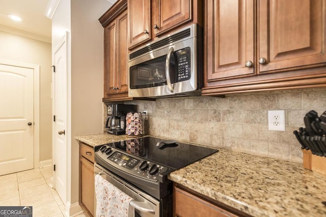 215 Wilsons Creek Bnd, Bonaire, GA 31005 - kitchen with stainless steel appliances, light stone counters, light tile patterned floors, ornamental molding, and backsplash
