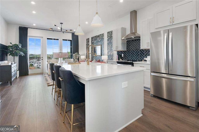 989 Bibbs Cir NW Unit 25, Atlanta, GA 30318 - kitchen with stainless steel appliances, wall chimney exhaust hood, recessed lighting, light countertops, and decorative backsplash