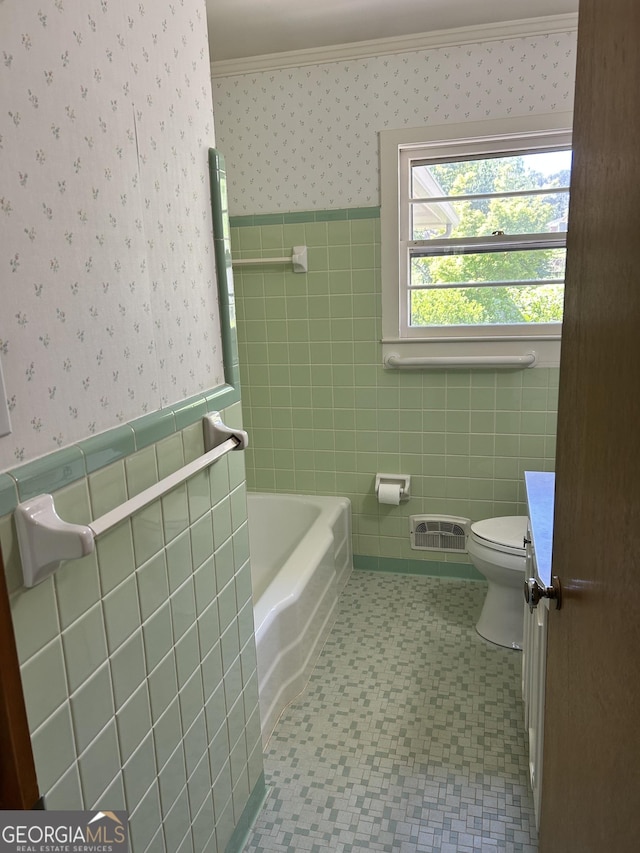 2334 Connally Dr, East Point, GA 30344 - full bathroom with wallpapered walls, tile walls, toilet, wainscoting, and a bathtub
