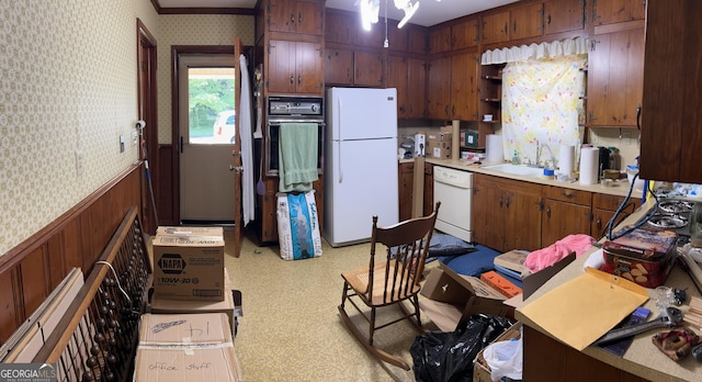 2334 Connally Dr, East Point, GA 30344 - kitchen featuring white appliances, wallpapered walls, wainscoting, light countertops, and a sink