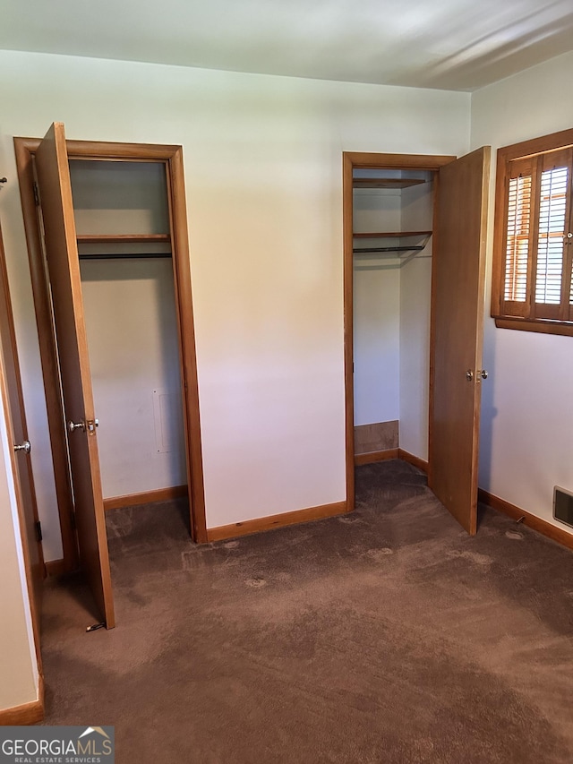 2334 Connally Dr, East Point, GA 30344 - unfurnished bedroom with dark colored carpet, multiple closets, and baseboards