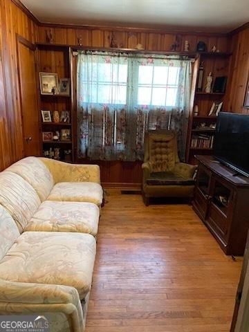 2530 Old Colony Rd, East Point, GA 30344 - living area featuring wooden walls, light wood-style floors, and ornamental molding