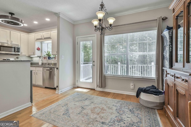 508 Las Brasis Ct, Peachtree City, GA 30269 - kitchen featuring stainless steel appliances, a chandelier, light wood-type flooring, crown molding, and a sink