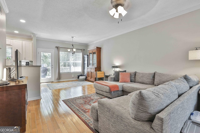508 Las Brasis Ct, Peachtree City, GA 30269 - living area with a chandelier, a ceiling fan, ornamental molding, light wood-style floors, and baseboards