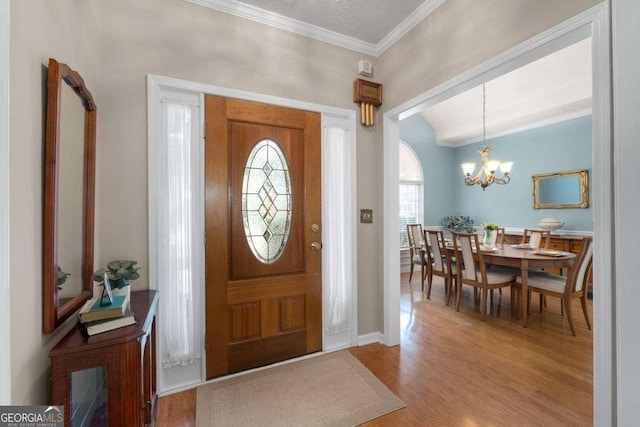 3027 Biltmore Woods Dr, Buford, GA 30519 - foyer with ornamental molding, wood finished floors, and a chandelier