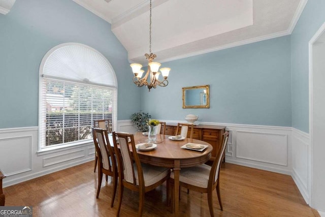3027 Biltmore Woods Dr, Buford, GA 30519 - dining room featuring a wainscoted wall, wood finished floors, a chandelier, crown molding, and lofted ceiling