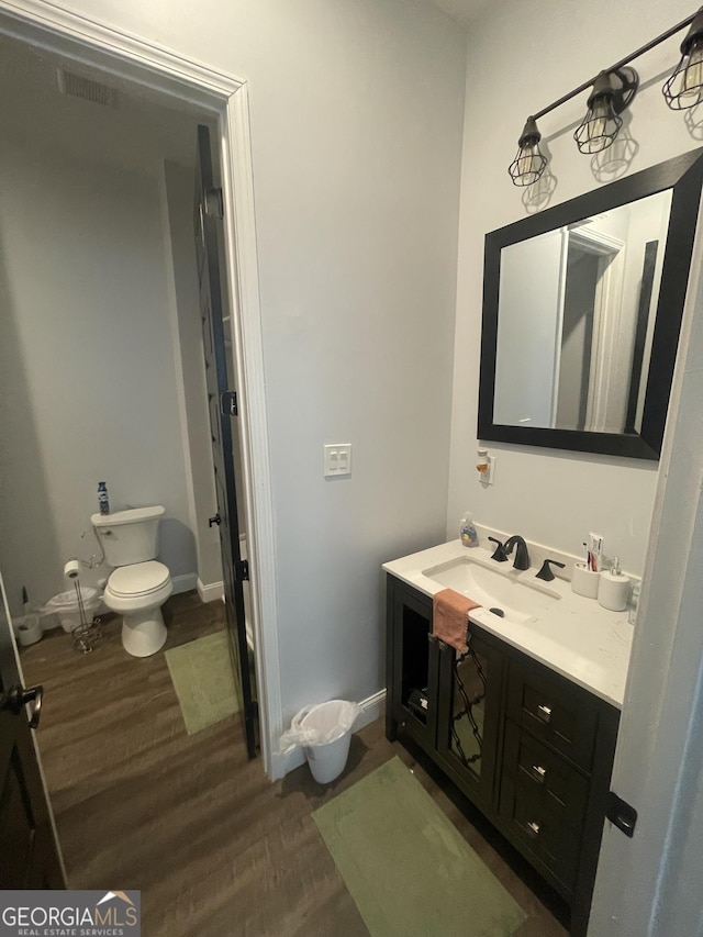 1333 Happy Hill Rd, Carrollton, GA 30116 - bathroom with toilet, vanity, wood finished floors, and baseboards