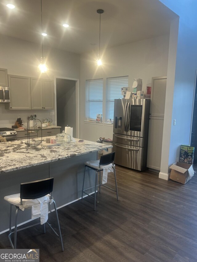 1333 Happy Hill Rd, Carrollton, GA 30116 - kitchen featuring stainless steel appliances, dark wood finished floors, a kitchen breakfast bar, light stone counters, and recessed lighting