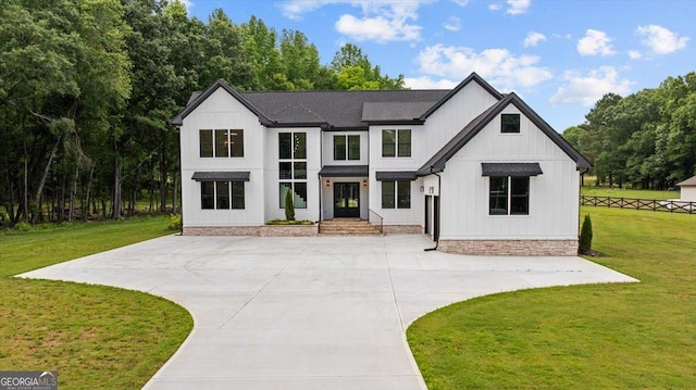 1604 Greendale Rd, Covington, GA 30014 - modern inspired farmhouse with a front lawn, concrete driveway, and roof with shingles