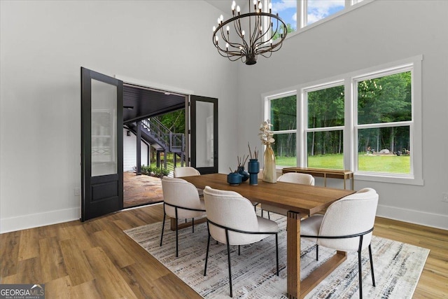 1604 Greendale Rd, Covington, GA 30014 - dining space featuring baseboards, a chandelier, wood finished floors, and a high ceiling