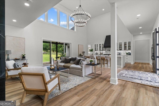 1604 Greendale Rd, Covington, GA 30014 - living area with a chandelier, a towering ceiling, light wood-style floors, and recessed lighting