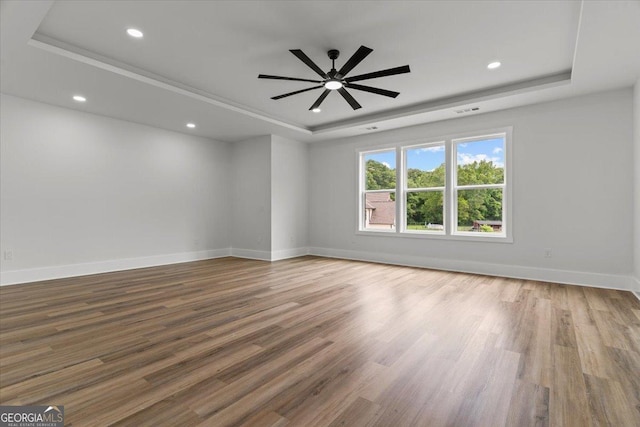 1604 Greendale Rd, Covington, GA 30014 - empty room with a tray ceiling, wood finished floors, baseboards, recessed lighting, and ceiling fan