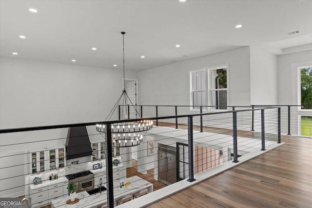 1604 Greendale Rd, Covington, GA 30014 - hall with wood finished floors, an upstairs landing, recessed lighting, and a chandelier