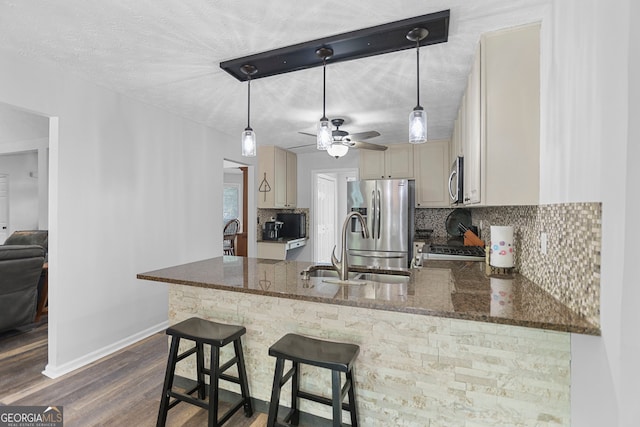 70 Otara Woods Ct, Newnan, GA 30263 - kitchen with stainless steel appliances, backsplash, a sink, baseboards, and a peninsula